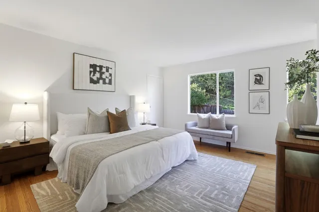 a bedroom with a bed and wooden floor