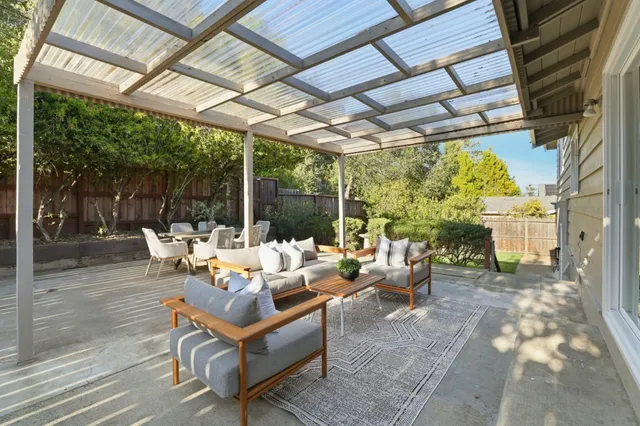 a living room with patio furniture and a garden