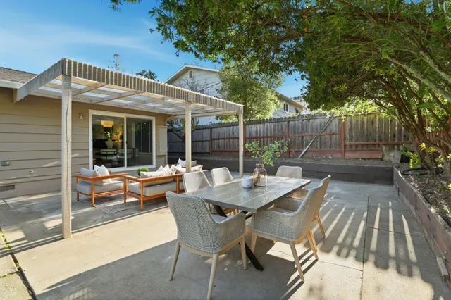 a view of a patio with table and chairs with wooden floor and fence