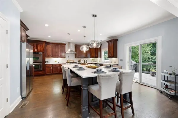 a kitchen with kitchen island granite countertop a sink stove and cabinets