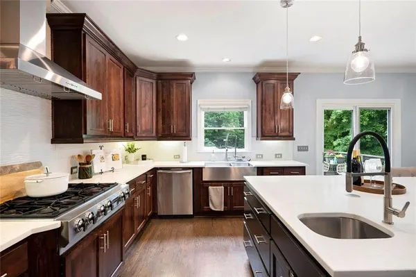 a kitchen with stainless steel appliances a sink a stove and a wooden cabinets