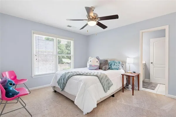 a bedroom with a bed a window and a flat screen tv