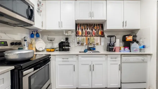 a kitchen with white cabinets and a sink