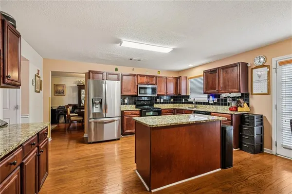 a kitchen with stainless steel appliances granite countertop a refrigerator stove and oven