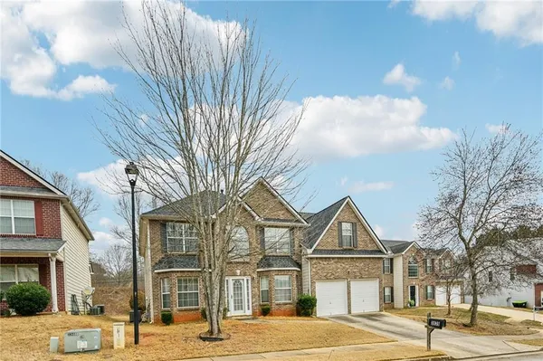 a view of a big house in a big yard with large trees