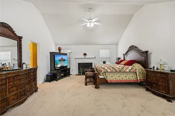 a bedroom with a bed chair and fireplace