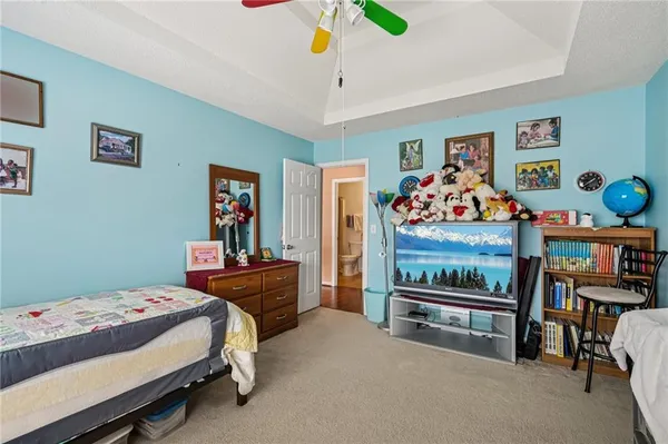 a bedroom with bed and paintings on the wall