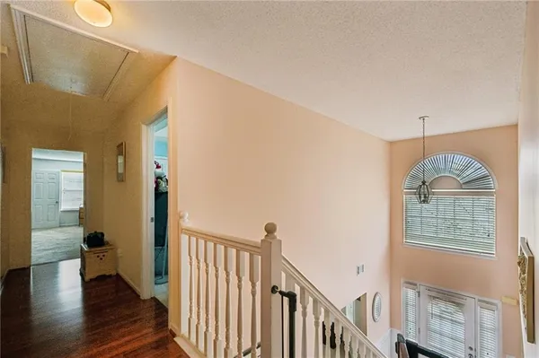 a view of a hallway with wooden floor and staircase