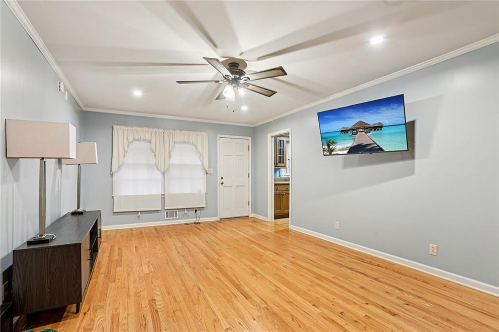 6300 East Stubbs Road Atlanta, GA 30349 - Photo 2 of 29 a view of an empty room with window a ceiling fan and wooden floor