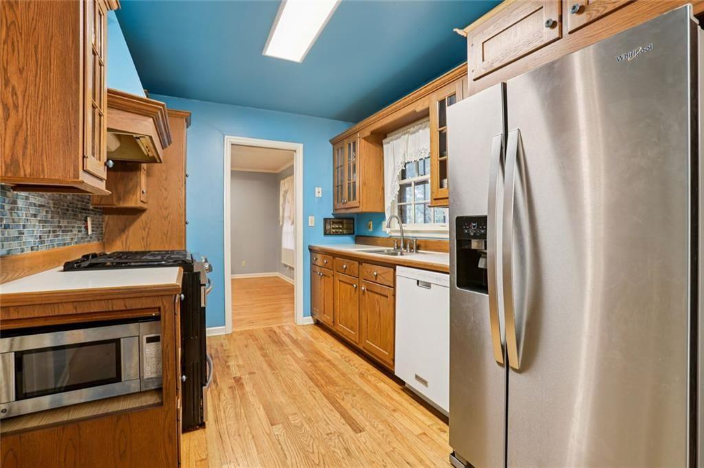 6300 East Stubbs Road Atlanta, GA 30349 - Photo 7 of 29 a kitchen with stainless steel appliances a refrigerator a stove a sink and dishwasher with wooden floor