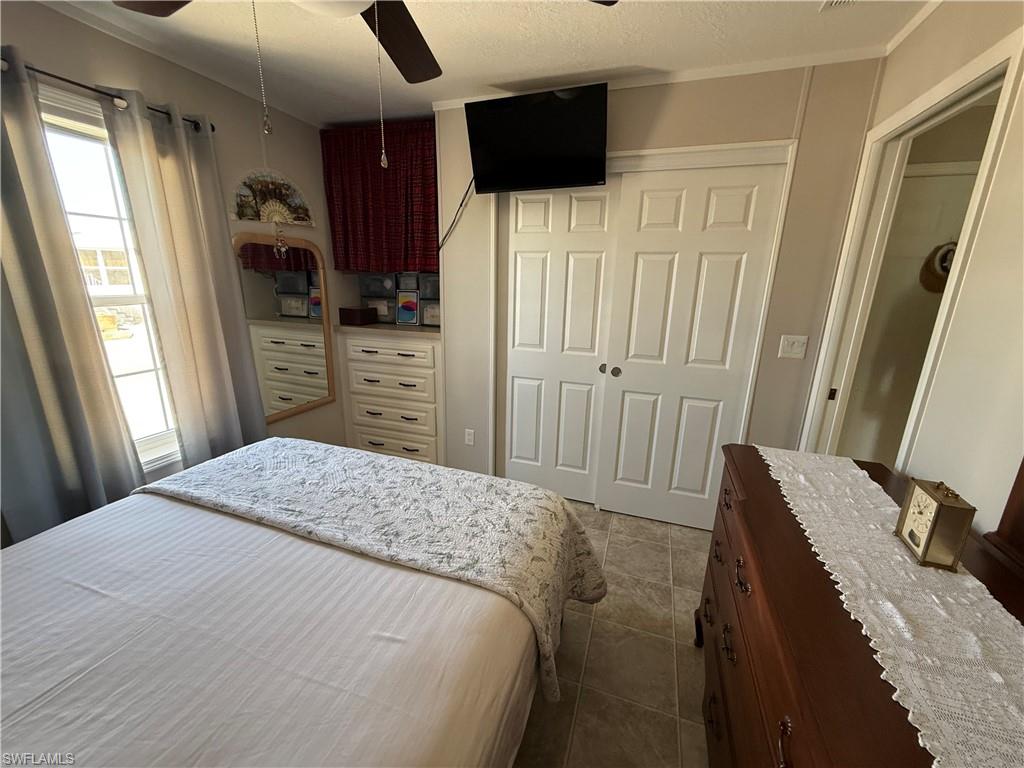 25 Bass Lane Naples, FL 34114 - Photo 9 of 17 a bedroom with a bed and a flat tv screen