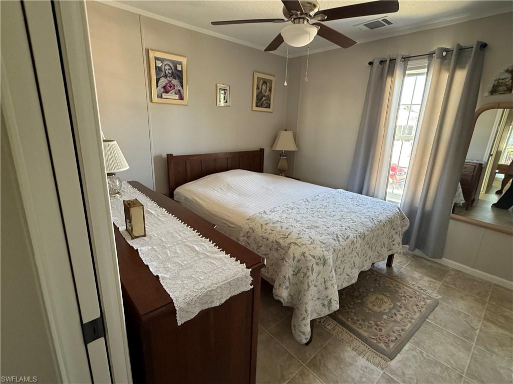 25 Bass Lane Naples, FL 34114 - Photo 8 of 17 a bed sitting in a bedroom next to a window