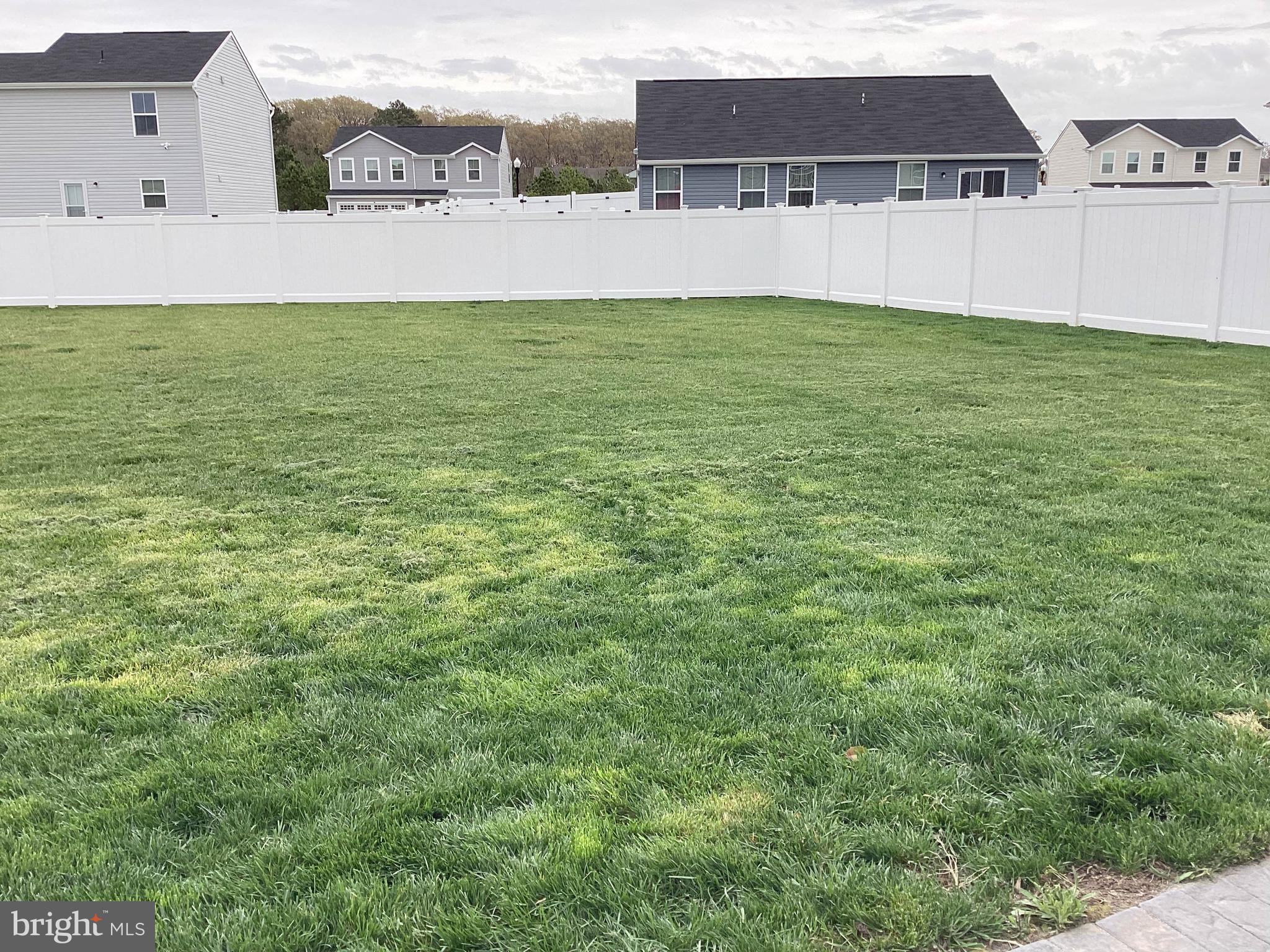 212 Bowline Drive Cambridge, MD 21613 - Photo 19 of 19 a view of a big yard with an buildings in the background