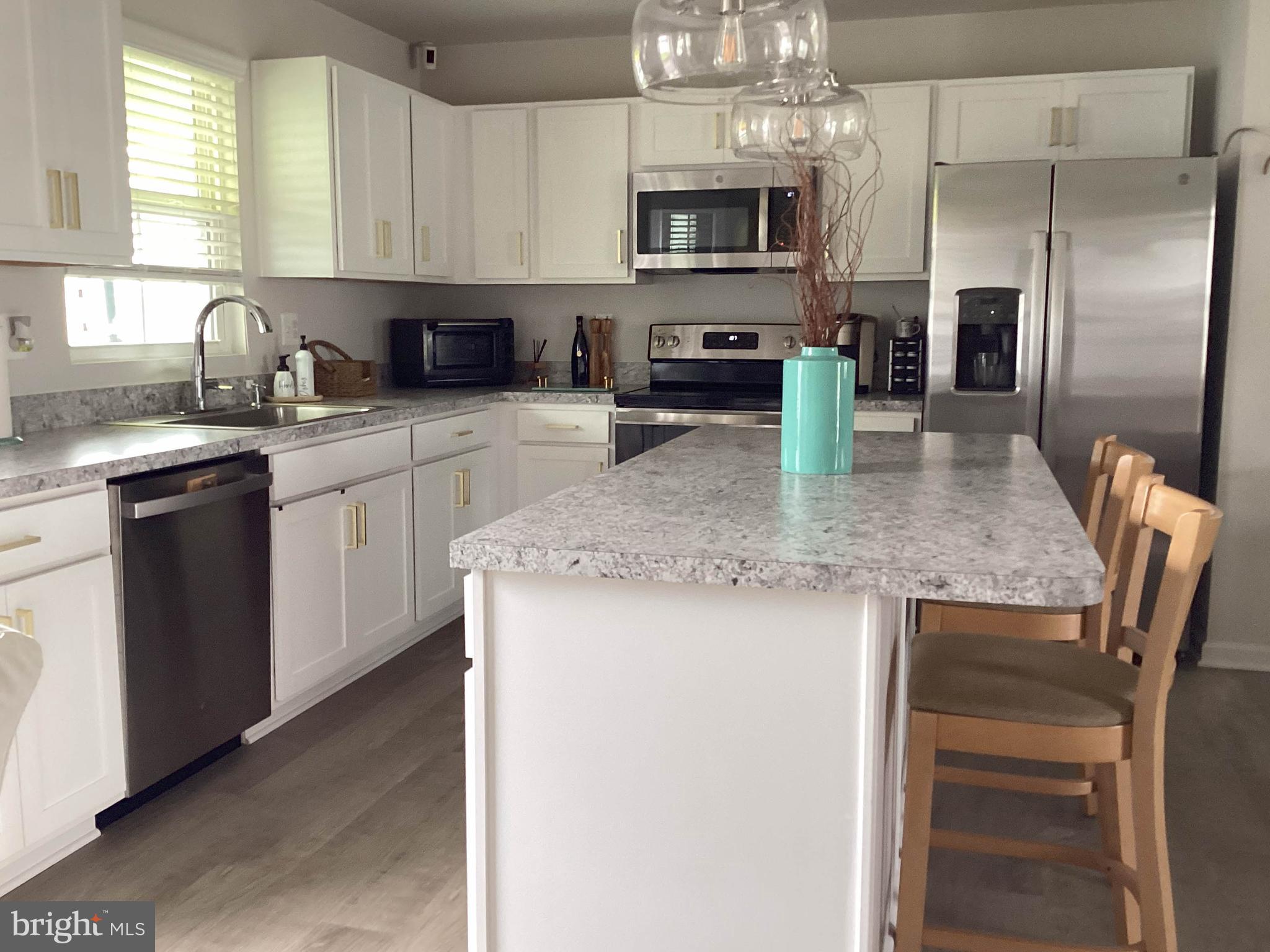 212 Bowline Drive Cambridge, MD 21613 - Photo 6 of 19 a kitchen with stainless steel appliances granite countertop a sink dishwasher a stove top oven a refrigerator with island and chairs