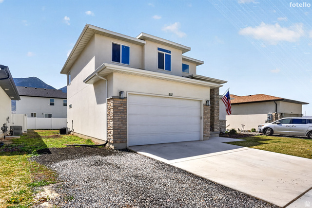 815 West Powderwood Lane Mapleton, UT 84664 - Photo 4 of 39 View of front facade featuring driveway, stone siding, stucco siding, and an attached garage