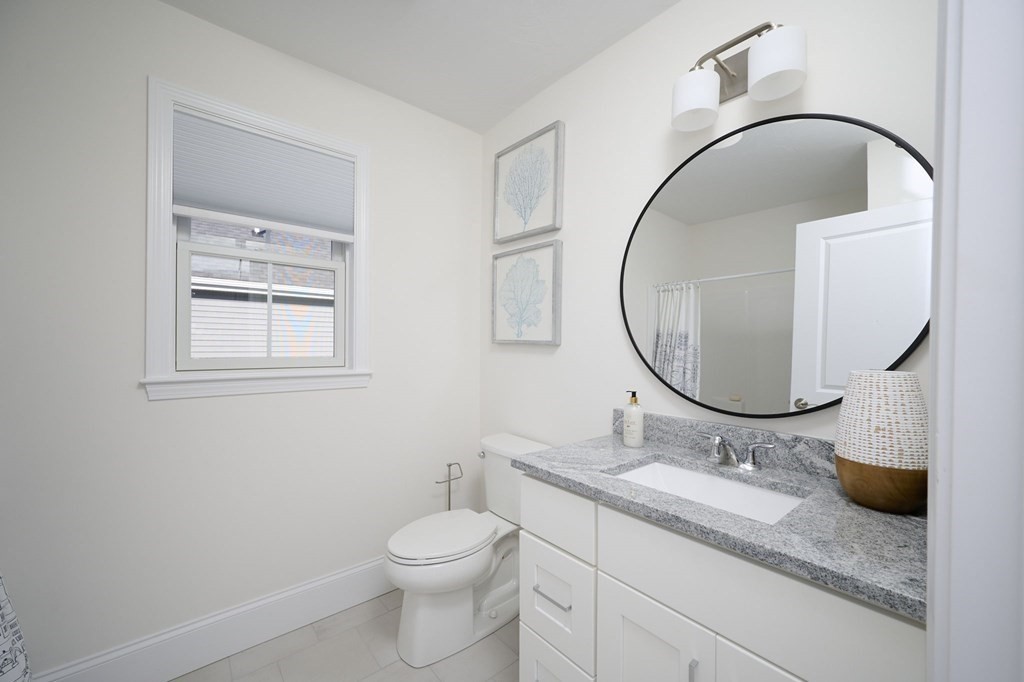 35 Metacomet Road, Unit 35 West Bridgewater, MA 02379 - Photo 19 of 34 a bathroom with a granite countertop toilet a sink and a mirror
