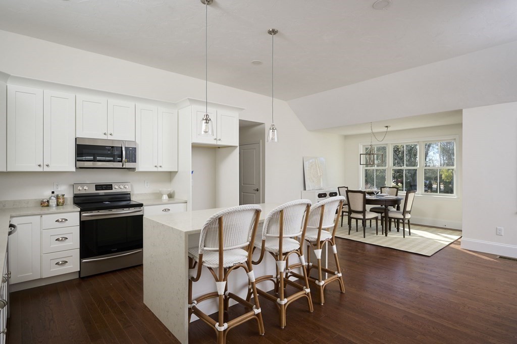 35 Metacomet Road, Unit 35 West Bridgewater, MA 02379 - Photo 4 of 34 a kitchen with stainless steel appliances a dining table chairs stove and white cabinets
