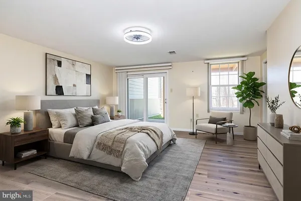 a bedroom with a large bed couch and windows