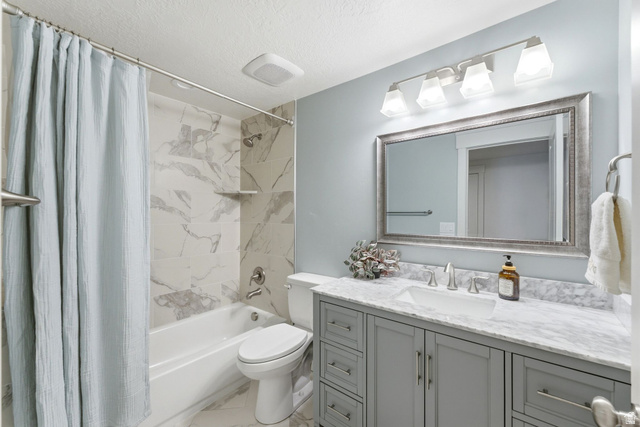 108 West Monte Rosa Lane Midway, UT 84049 - Photo 30 of 48 Bathroom featuring a built-in tub with tile surround, a single vanity with a stone countertop, an undermount sink, and a framed mirror