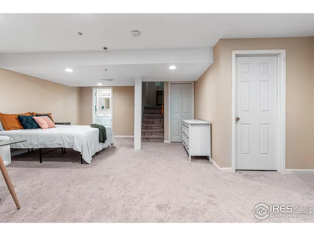 a spacious bedroom with a bed and a lamp