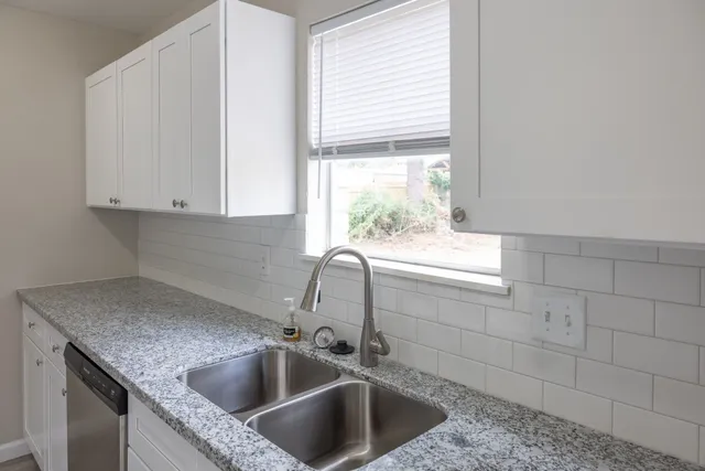 a kitchen with granite countertop a sink and a window
