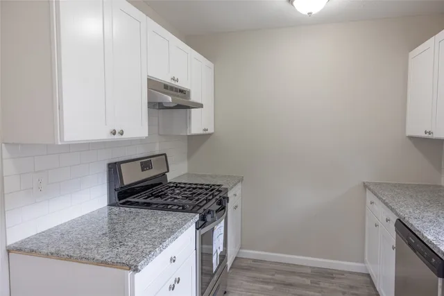 a kitchen with stainless steel appliances granite countertop a sink stove and cabinets