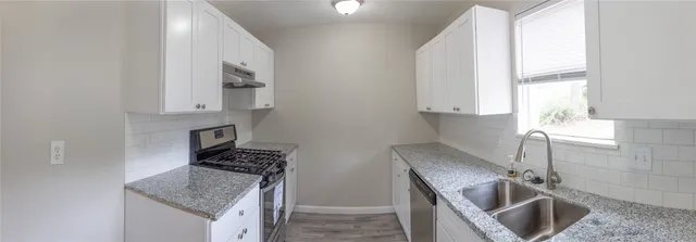 a kitchen that has a sink a stove and a counter top space