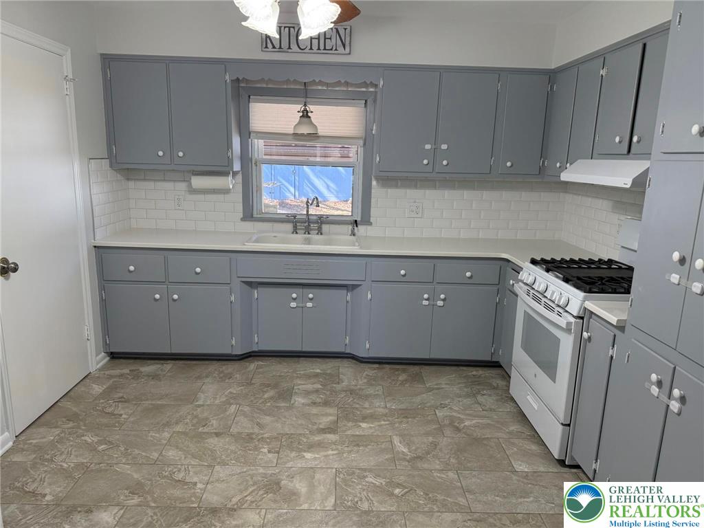 2229 Rodgers Street Bethlehem, PA 18017 - Photo 2 of 17 a kitchen with granite countertop a stove a sink and a white cabinets