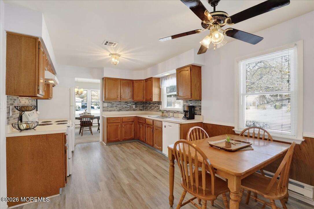 32 Abbey Road Brick, NJ 08723 - Photo 13 of 44 a kitchen with granite countertop a stove a sink a kitchen island with a dining table and chairs