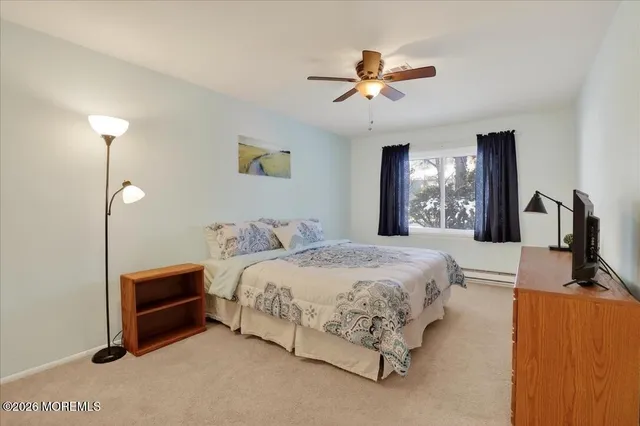 a bedroom with a bed a chandelier and dresser
