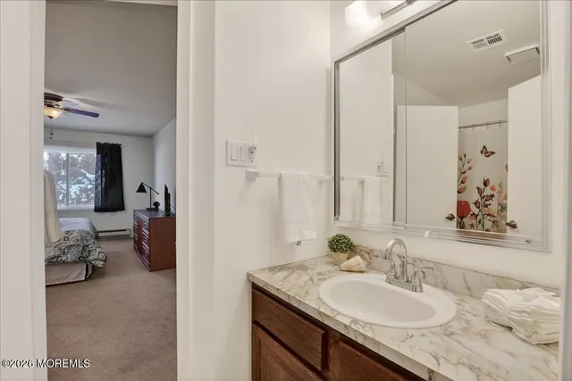 a en suite bathroom with a granite countertop sink and a mirror