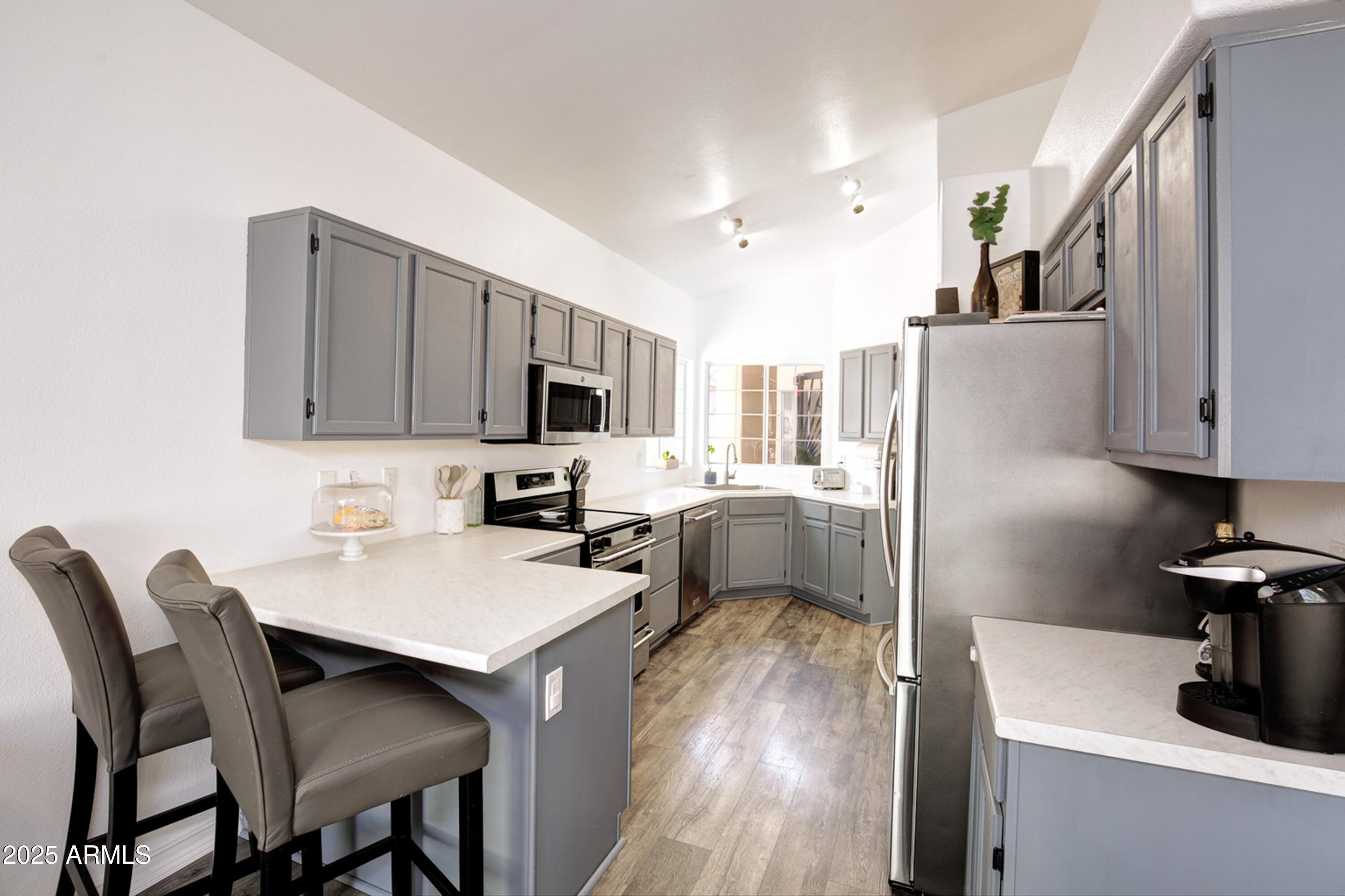 6458 East Raftriver Street Mesa, AZ 85215 - Photo 23 of 75 a kitchen with a table chairs refrigerator and microwave