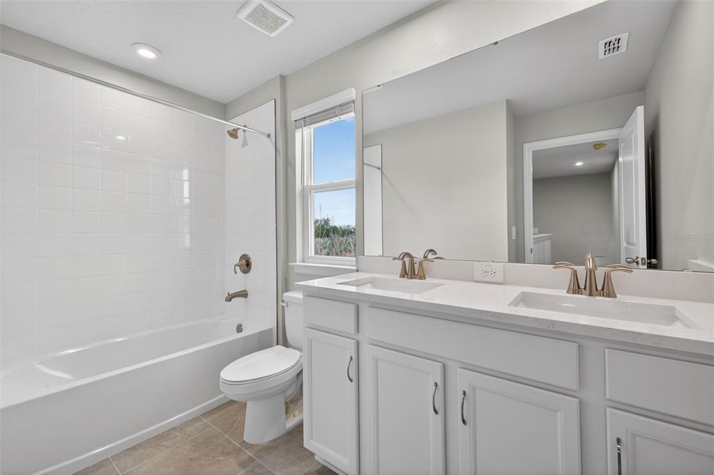 3350 Timber Xing Avenue Brandon, FL 33511 - Photo 26 of 35 a bathroom with a double vanity sink toilet mirror and bathtub
