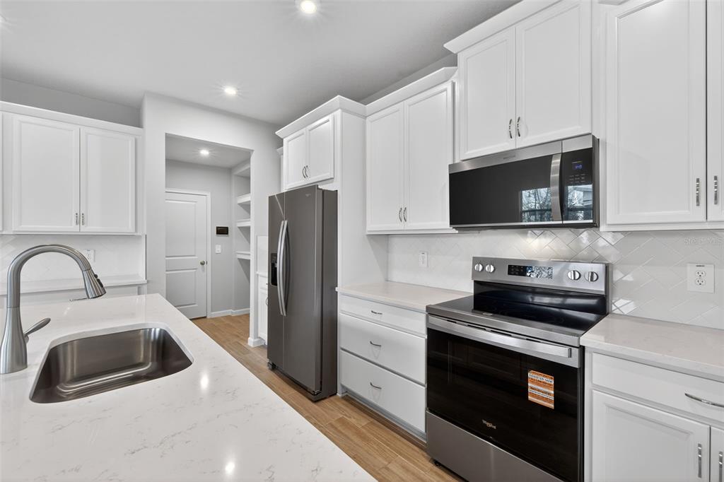 3350 Timber Xing Avenue Brandon, FL 33511 - Photo 7 of 35 a kitchen with stainless steel appliances a stove a sink a refrigerator and cabinets