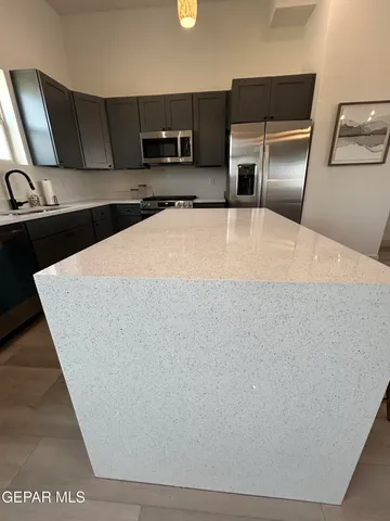 a large kitchen with stainless steel appliances a refrigerator