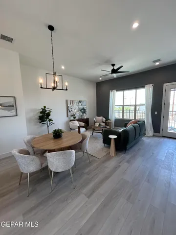 a living room with furniture a chandelier and a wooden floor