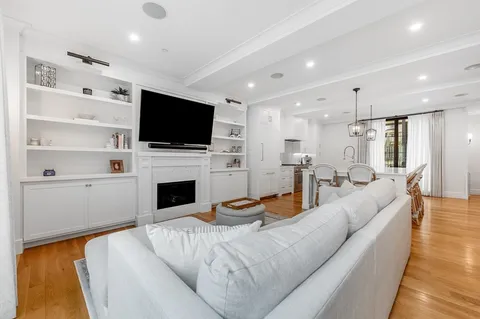 a living room with furniture a flat screen tv and a fireplace