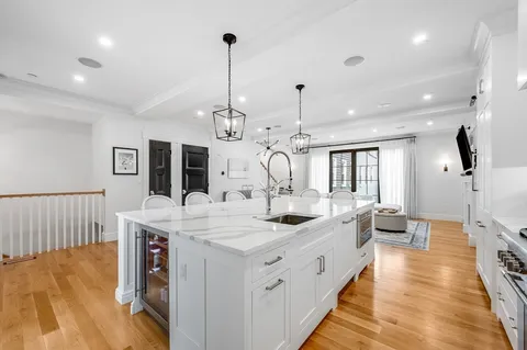 a large kitchen with kitchen island a island a sink a stove and a wooden floors