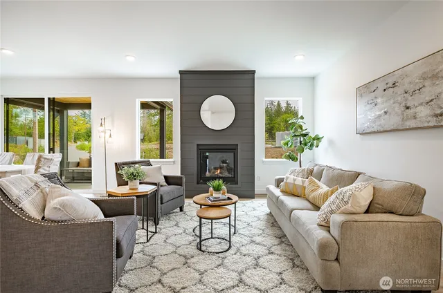 a living room with furniture a fireplace and a large window