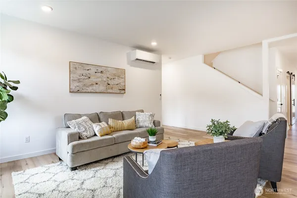 a kitchen with stainless steel appliances kitchen island granite countertop a refrigerator a stove a microwave oven a dining table and chairs with wooden floor