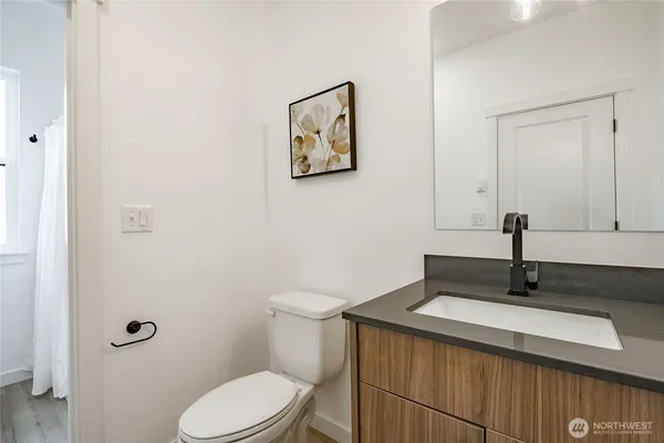 a bathroom with a granite countertop sink a toilet and a mirror
