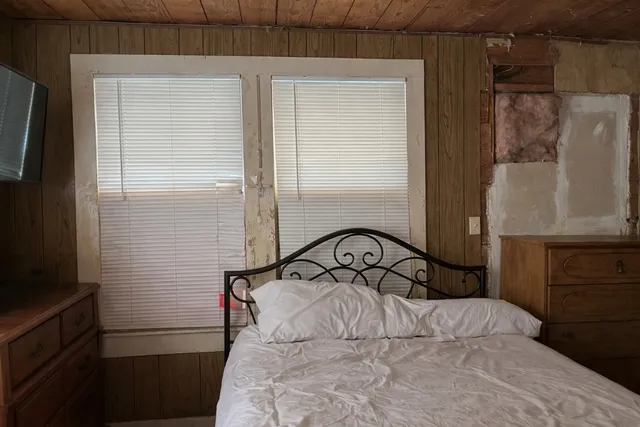 a bedroom with a bed and a mirror