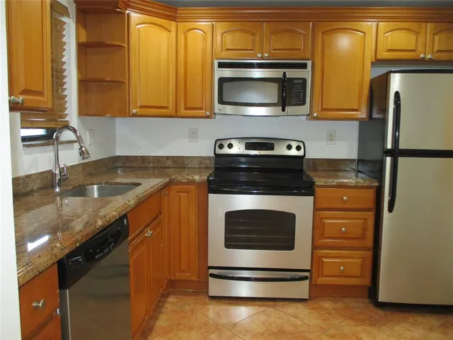 a kitchen with stainless steel appliances granite countertop a stove microwave and refrigerator