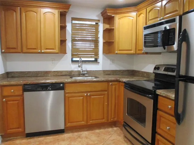 a kitchen with stainless steel appliances granite countertop a stove a sink and a microwave