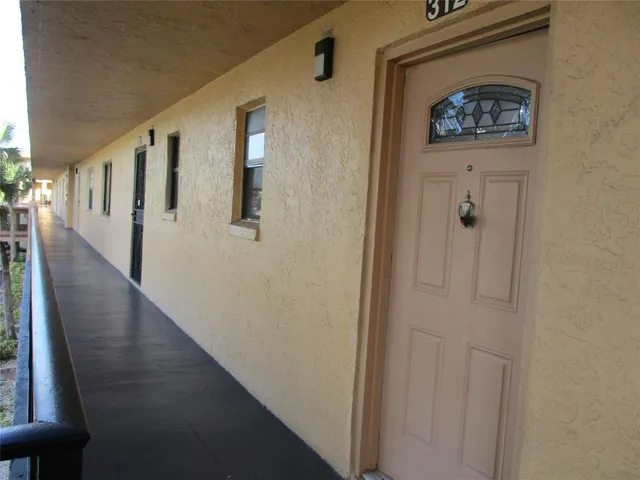 a view of a hallway with wooden floor and entryway