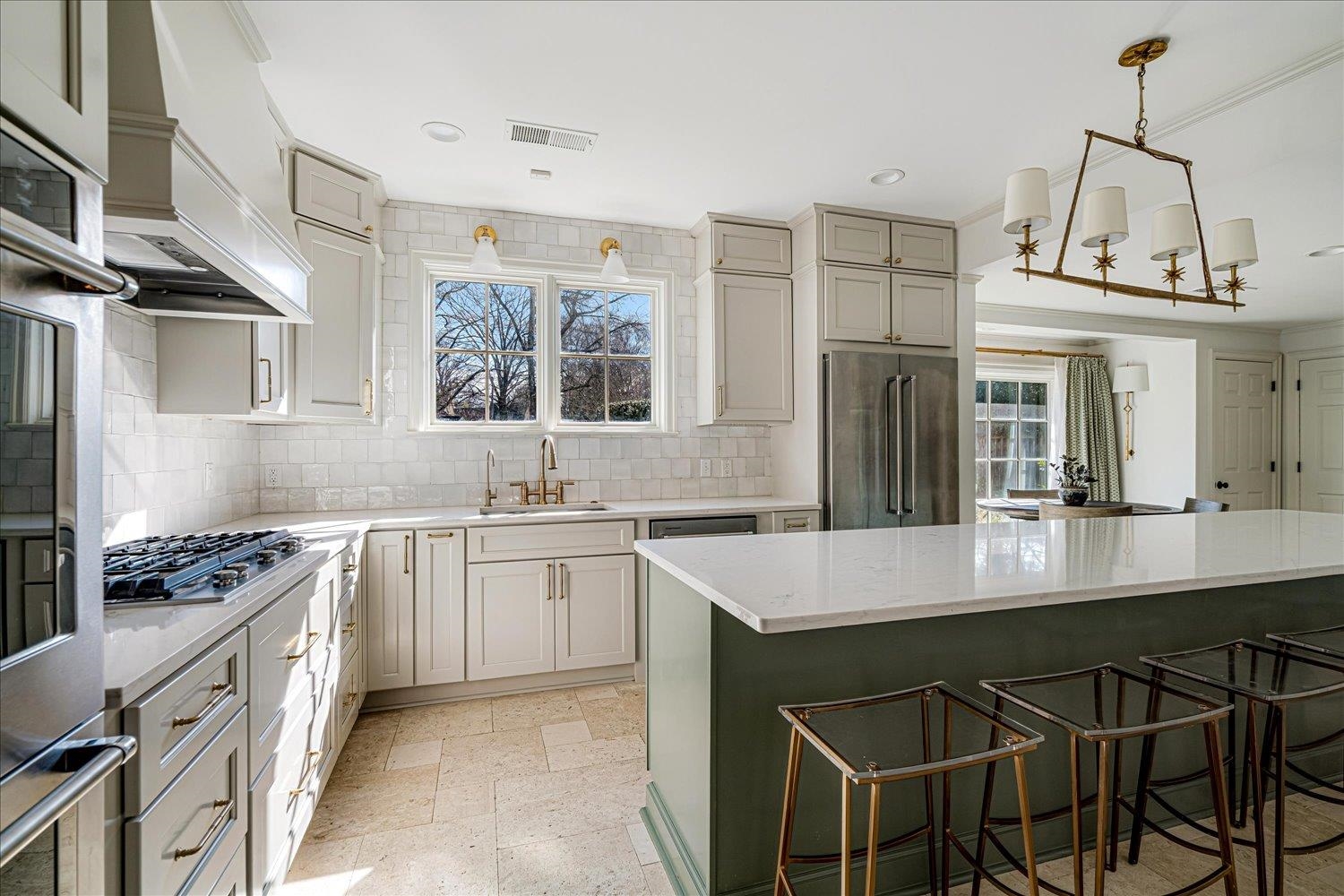 4160 Tuckahoe Road Memphis, TN 38117 - Photo 11 of 39 Kitchen featuring stone tile floors, a kitchen bar, stainless steel appliances, and light stone counters
