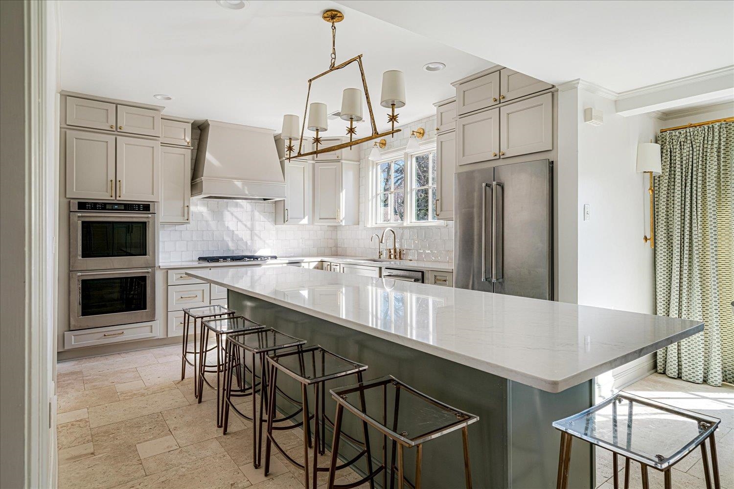 4160 Tuckahoe Road Memphis, TN 38117 - Photo 10 of 39 Kitchen featuring a breakfast bar, appliances with stainless steel finishes, hanging light fixtures, gray cabinets, and custom range hood