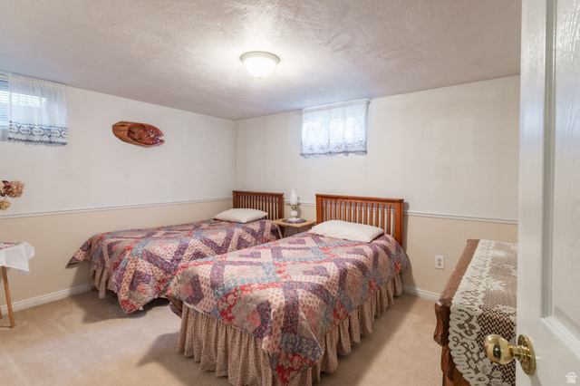 2344 East 3500th Street South Vernal, UT 84078 - Photo 26 of 53 Carpeted room featuring two wood-frame beds, painted walls with wainscoting, and a ceiling-mounted light fixture