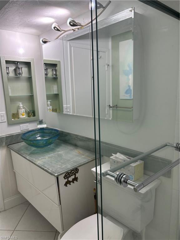 Undisclosed Address Naples, FL 34112 - Photo 20 of 35 Bathroom with toilet, tile patterned flooring, vanity, and a textured ceiling