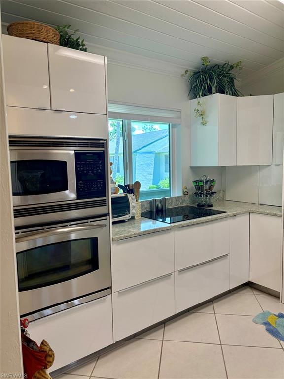 Undisclosed Address Naples, FL 34112 - Photo 2 of 35 Kitchen with light tile patterned floors, ornamental molding, modern cabinets, stainless steel appliances, and white cabinets